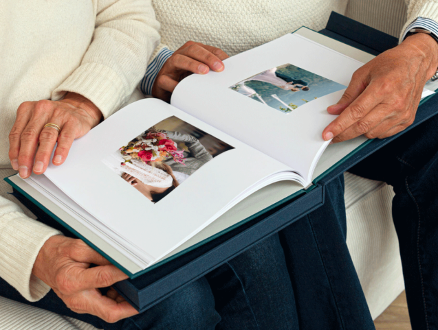 deux personnes âgée admirent l'album photo du mariage de leur enfants, proposés par Laurent Agier, photographe dans le var