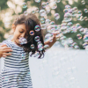 Une jeune fille s'amuse au milieu des bulles dans un mariage, photographiée par Laurent Agier